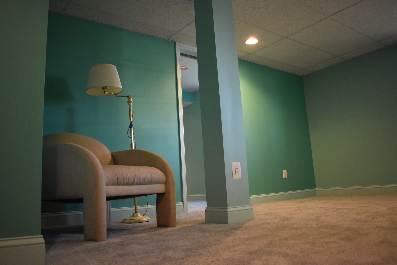 Finished basement sitting area with recessed lights and painted walls