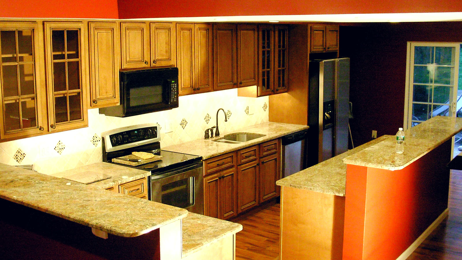 Kitchen remodel with red accent wall, honey-oak cabinets, and granite counters — The Remediation Tech